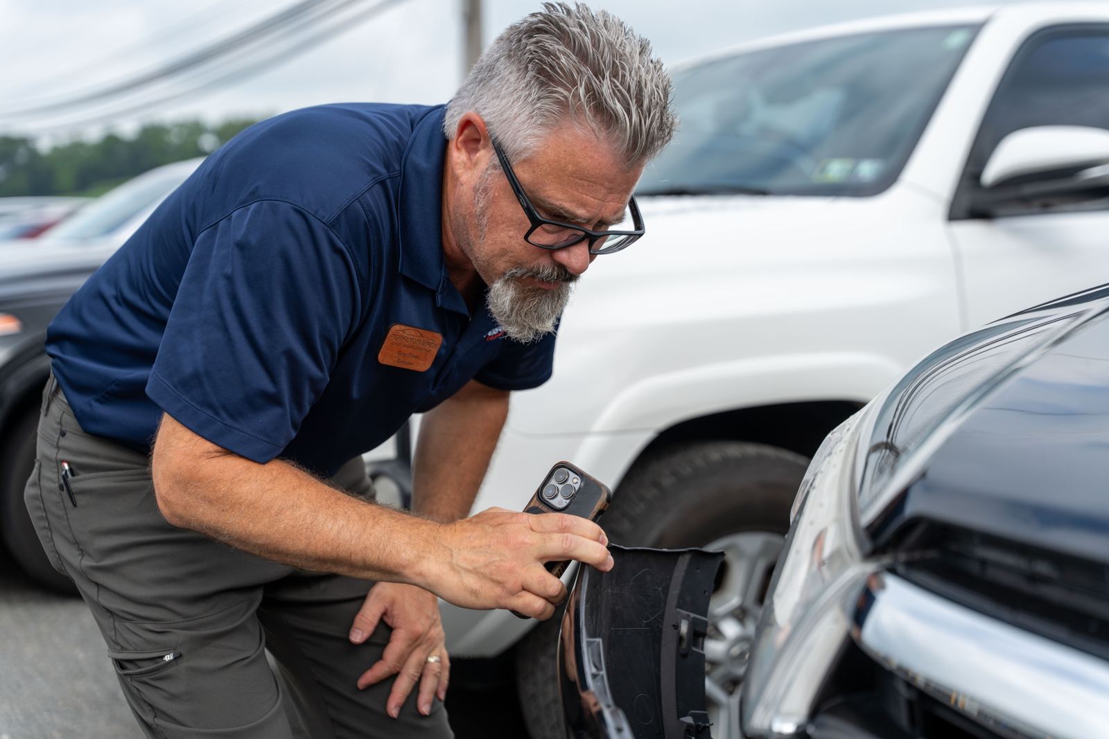 Estimator inspecting accident damage on an SUV