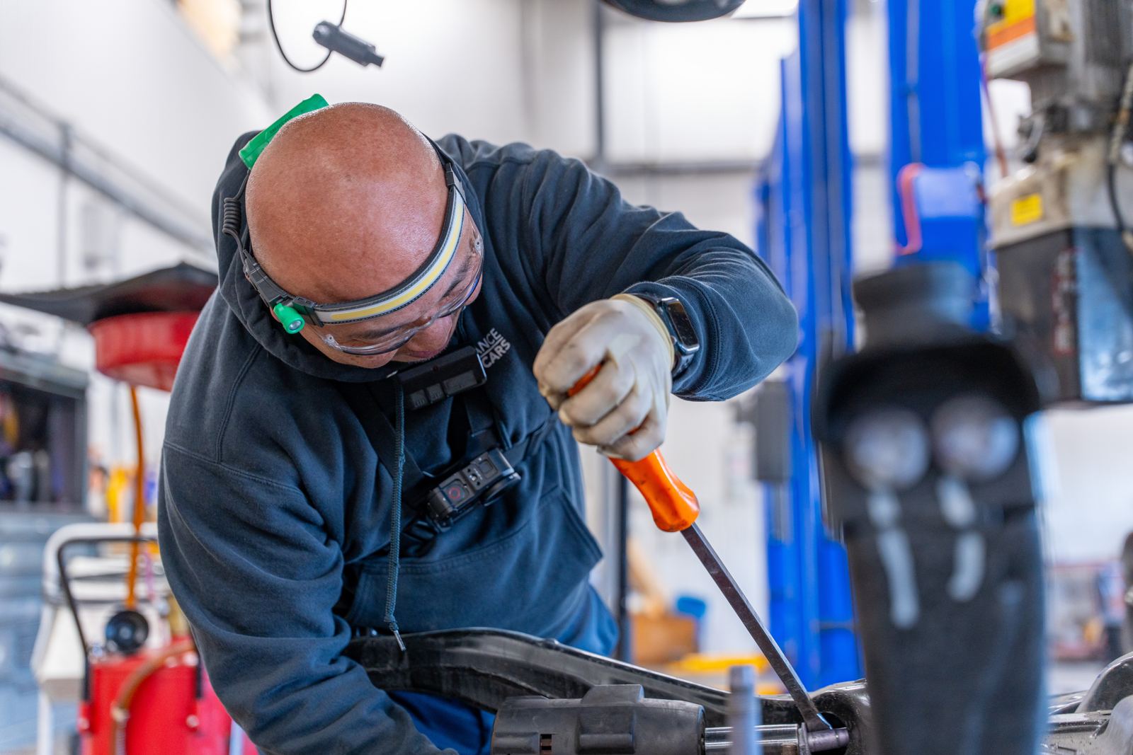 Technician working on a front suspension at Performance Collision Center